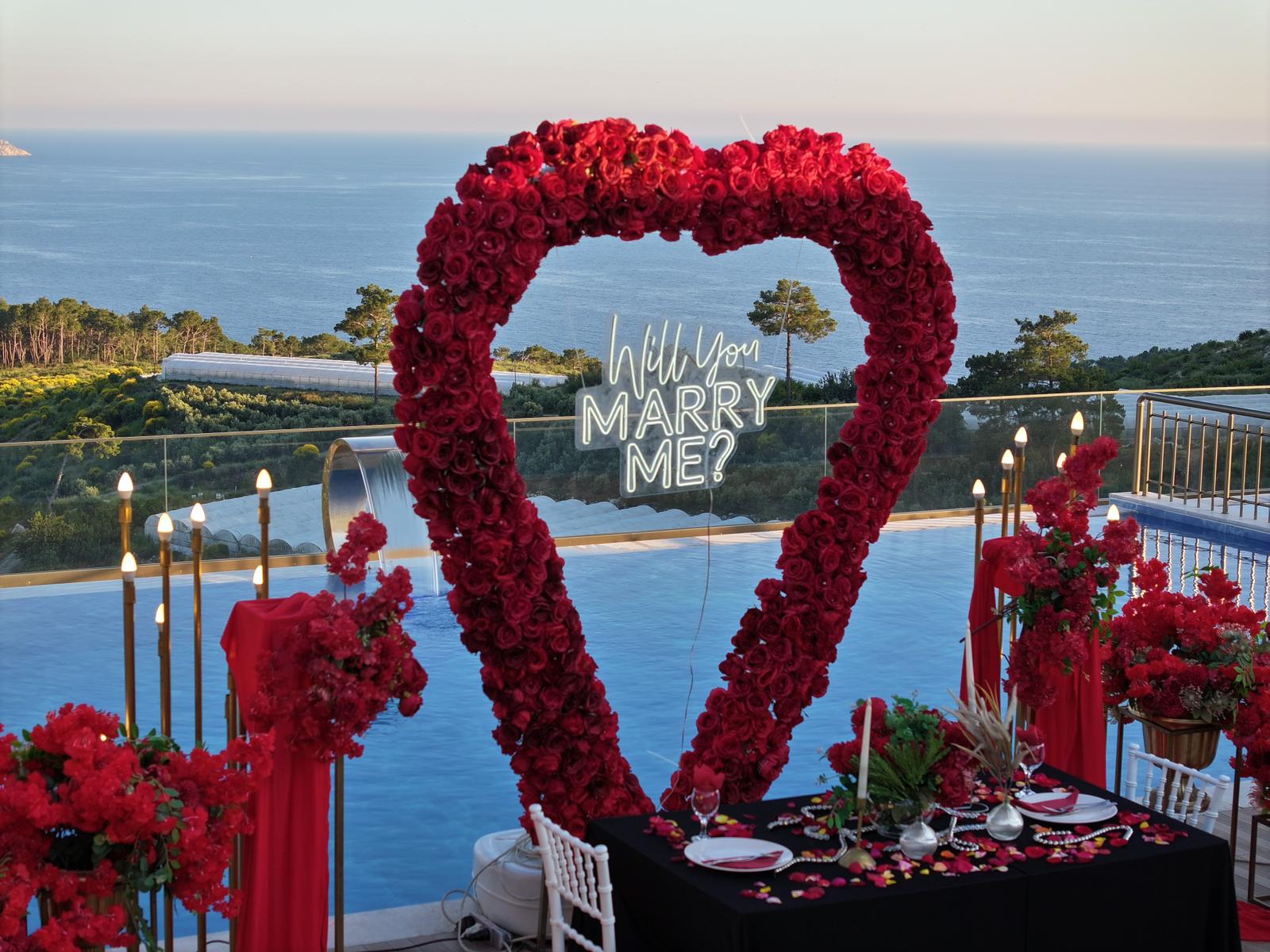 Güllerle süslenmiş kalp şeklinde evlilik teklifi alanı